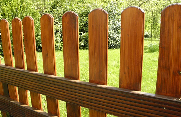 Holzzaun vor grünem Rasen